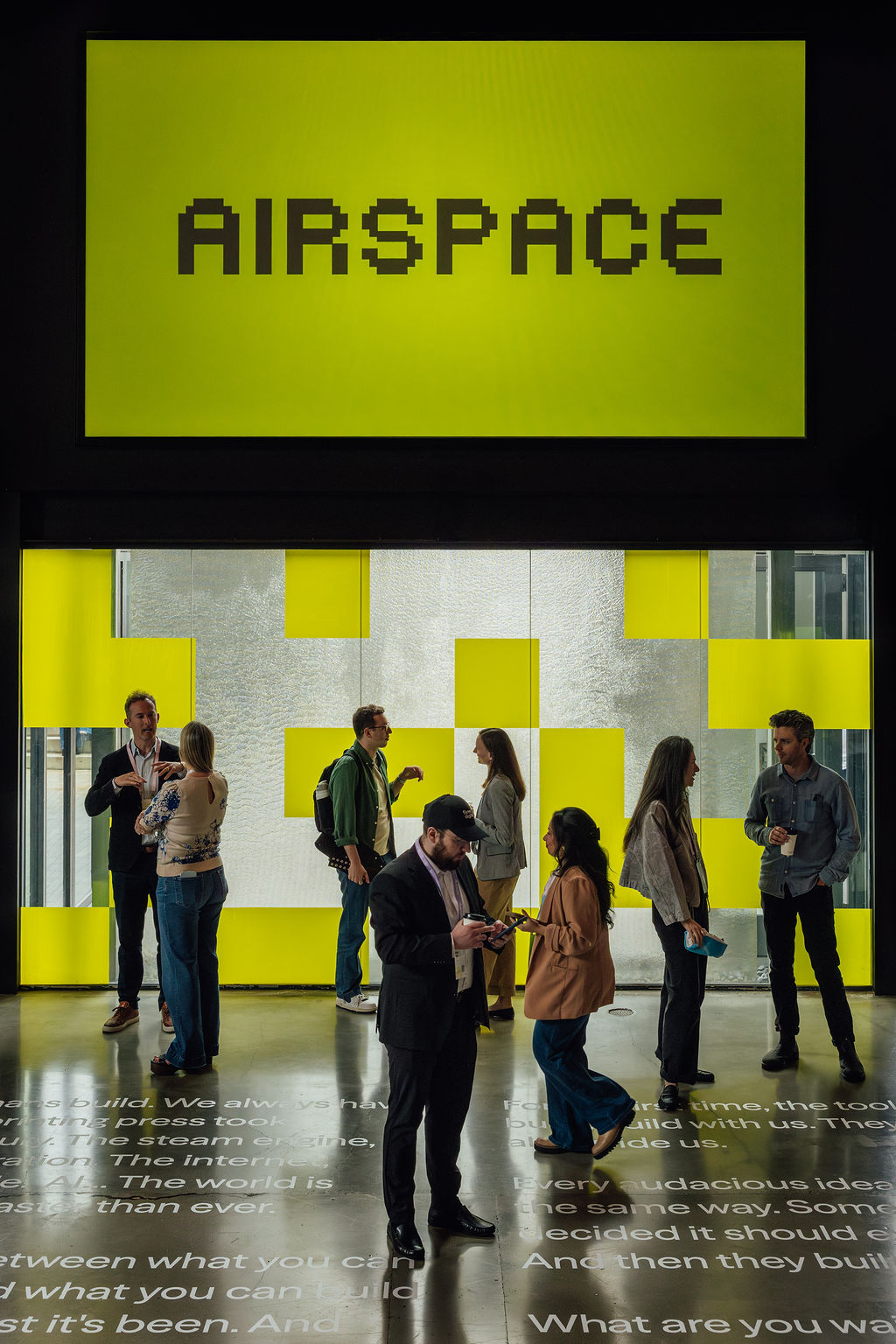 Guests beneath the Airspace identity and projected manifesto typography