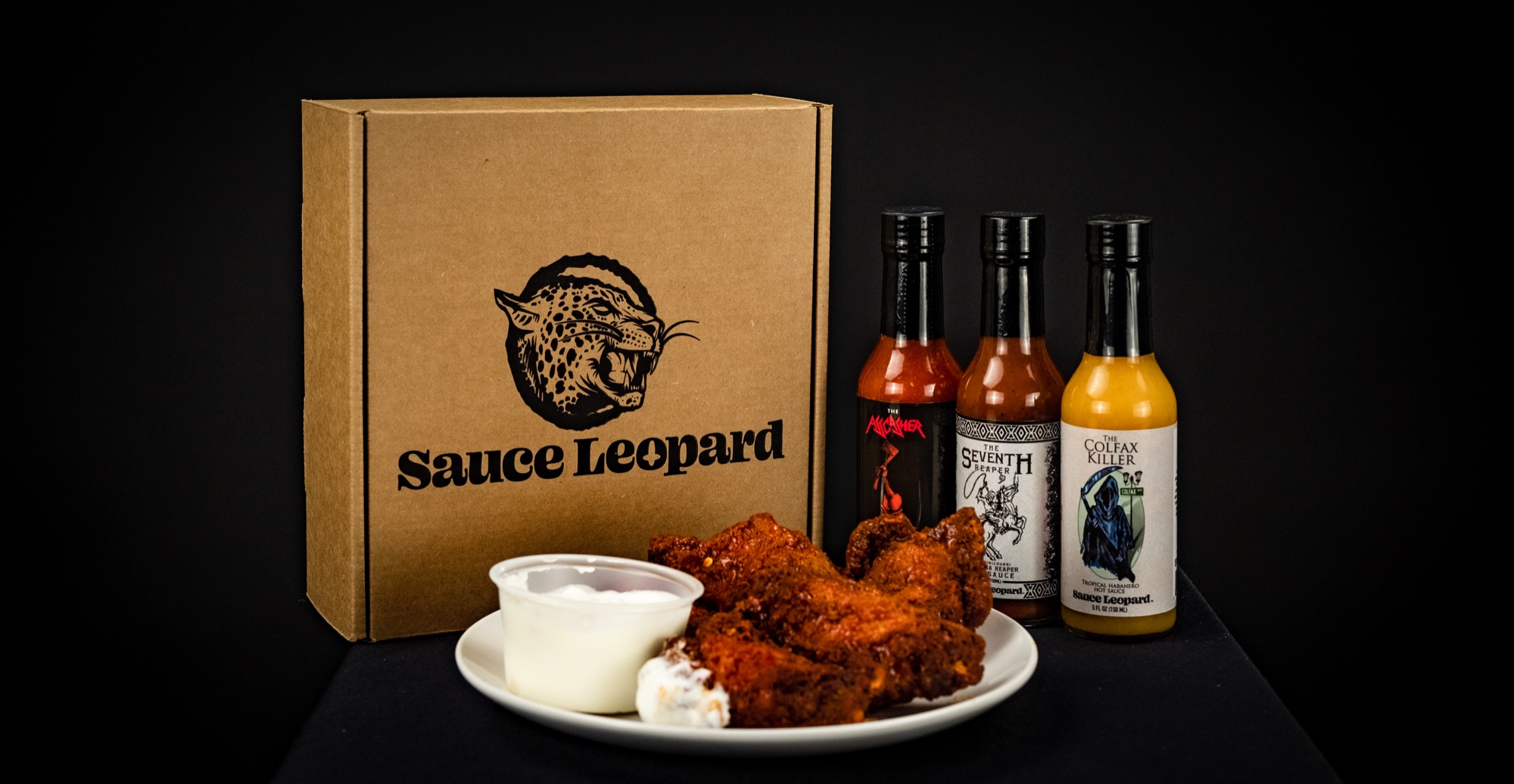 Sauce Leopard bottles, packaging, and wings arranged for a summer campaign